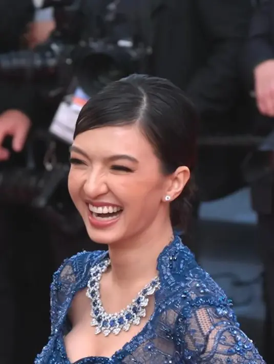 Kebaya biru tersebut memiliki ekor panjang yang menjuntai di belakangnya.