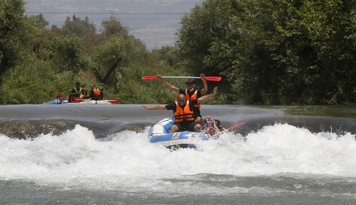 Umat muslim merayakan liburan Idul Fitri dengan rafting menyusuri Sungai Hasbani, Anak Sungai Yordan, di Kfar Blum, Israel, Rabu (27/5/2020). Pemerintah Israel mengurangi pembatasan aktivitas terkait pandemi virus corona COVID-19. (JALAA MAREY/AFP)