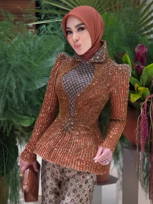 Wajahnya dipulas makeup glam flawless dengan blush on coral serasi dengan lipstiknya. Hiasan matanya dibuat bold.  [@princessyahrini]