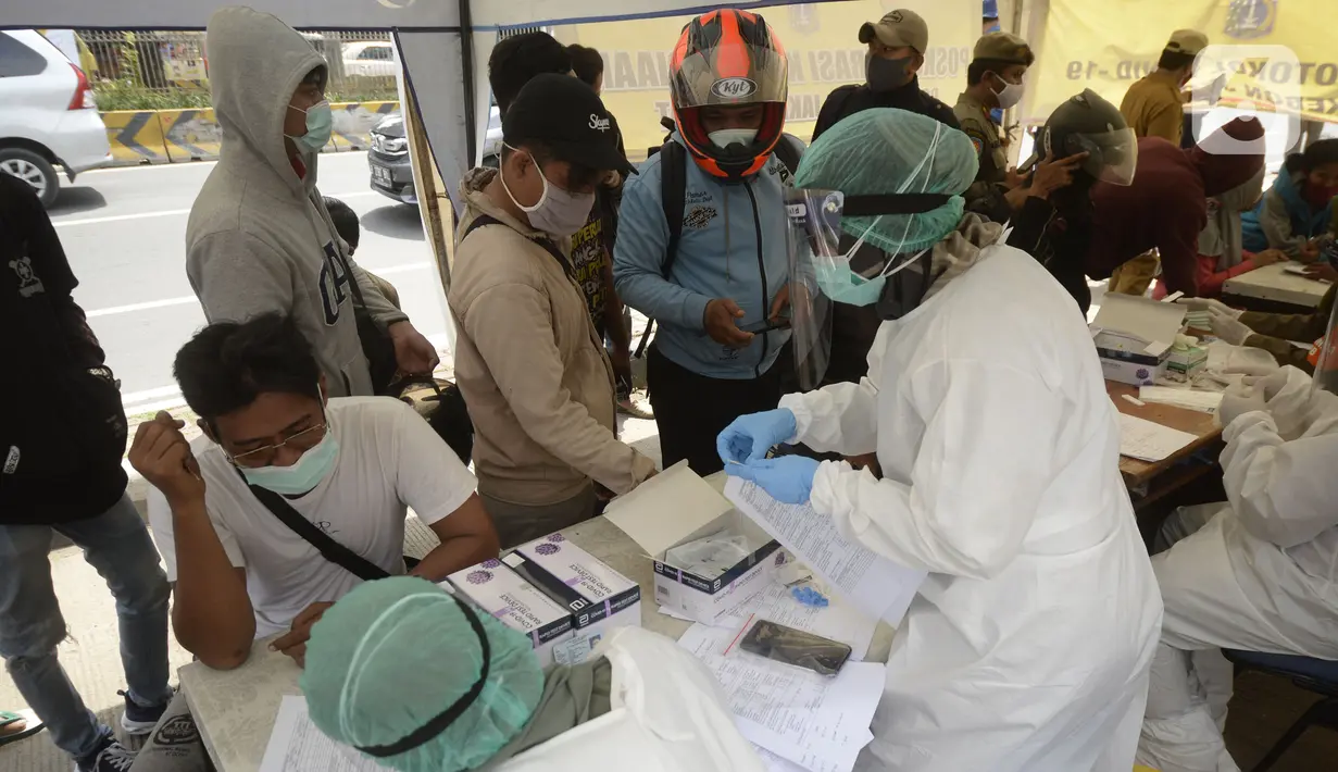 Pengendara yang terjaring razia masker antre menjalani rapid test di Jalan Panjang, Kedoya, Jakarta Barat, Senin (2812/2020). Pengendara yang tidak mengenakan masker langsung menjalani rapid test antigen gratis untuk mencegah penularan COVID-19. (merdeka.com/Dwi Narwoko)