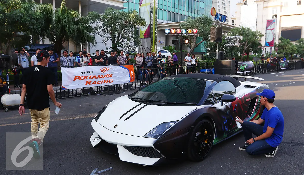 Sejumlah anak muda tengah menggraviti mobil Lamborghini di Senayan City, Jakarta, Jumat (3/6). Pertamina menggandeng Lamborgini untuk menyelenggarakan program menarik pada acara partnership launcing Kreativitas Tanpa Batas. (Liputan6.com/Angga Yuniar)