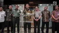 Menko Polhukam Wiranto (tengah) memberi keterangan usai rapat di Kemenkopolhukam, Jakarta, Jumat (6/10). Dalam kesempatan itu turut hadir Kepala Badan Intelijen Negara (BIN) Budi Gunawan serta Menhan Ryamizard Ryacudu. (Liputan6.com/Faizal Fanani)
