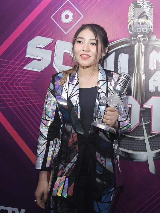 Penyanyi dangdut Via Vallen menunjukkan piala penghargaan usai acara SCTV Music Awards 2019 di Studio 6 Emtek City, Jakarta, Jumat (26/4). Via Vallen memboyong gelar Kategori Lagu Pop Paling Ngetop melalui "Meraih Bintang" yang sempat menjadi Theme Song Asian Games 2018. (Fimela.com/Bambang E. Ros)