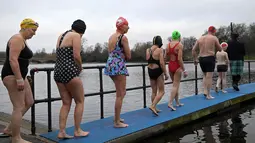 Sejumlah peserta bersiap untuk mengikuti lomba berenang di Danau Serpentine di Hyde Park, London, Inggris, Minggu (25/12). Lomba ini digelar untuk merayakan Natal 2016. (REUTERS/Toby Melville)
