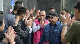 Vonis tersebut dibacakan majelis Hakim Pengadilan Tindak Pidana Korupsi, Jakarta, pada Kamis (26/2/2026). Tampak dalam foto, mantan Direktur Utama PT Pertamina Patra Niaga, Riva Siahaan (tengah), dikawal menuju ke ruang sidang untuk mendengar pembacaan vonis oleh majelis hakim Pengadilan Tindak Pidana Korupsi, Jakarta, Kamis (26/2/2026). (BAY ISMOYO/AFP)