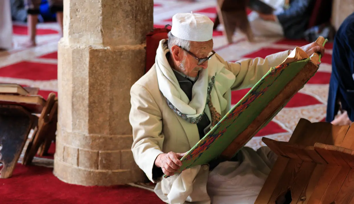 Pria Muslim membaca Al-qur'an pada hari pertama Ramadhan di Masjid Al-Kabir di ibu kota Yaman, Sanaa, 2 April 2022. Pemberontak Huthi yang didukung Iran dan koalisi pimpinan Saudi sepakat untuk mematuhi gencatan senjata dua bulan, yang mulai berlaku pada hari pertama puasa. (MOHAMMED HUWAIS/AFP)