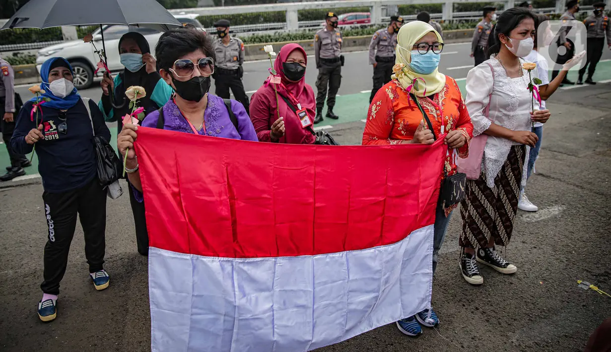 Massa dari Jaringan Pembela Hak Perempuan Korban Kekerasan Seksual membawa bendera Merah Putih di depan Gedung DPR, Jakarta, Rabu (22/12/2021). Mereka mendesak DPR mengesahkan rancangan undang-undang Tindak Pidana Kekerasan Seksual (RUU TPKS) sebagai RUU Inisiatif DPR RI (Liputan6.com/Faizal Fanani)