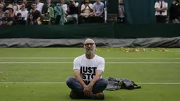 Dua aktivis lingkungan melompat dari tribun penonton di Court 18 dan mengganggu pertandingannya. (AP Photo/Alastair Grant)