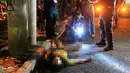 Petugas memeriksa jenazah pria di pinggir jalan Malate, Manila (29/8). Kepolisian Filipina mencatat lebih dari 1.900 orang tewas dalam penumpasan bandar narkoba, 750 korban diduga bandar dan sisanya masih misteri. (REUTERS/Romeo Ranoco)