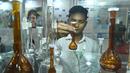 Seorang pengunjung mengamati sebuah gelas labu laboratorium dalam Pameran Farmasi Asia di Dhaka, Bangladesh, Jumat (28/2/2020). Pameran yang berfokus pada produk dan layanan medis serta teknologi farmasi ini berlangsung pada28 Februari hingga 1 Maret 2020. (Xinhua/Str)