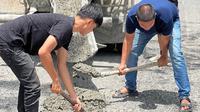 Aksi sejumlah pemuda perbaiki jalan rusak di Pekanbaru karena pemerintah hanya umbar janji. (Liputan6.com/M Syukur)