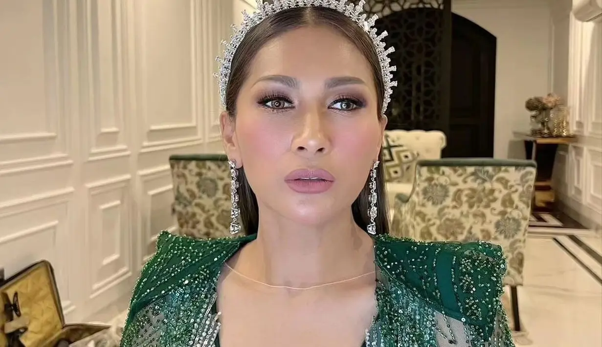 Tata Janeeta tampil glamor dengan dress bertabur beads nuansa emerald green dan beberapa aksesori mewah seperti tiara dan anting. [@adit_adcee]