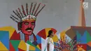 Warga melintas di samping mural bertema Asian Games 2018 di kolong flyover Universitas Indonesia, Depok, Jawa Barat, Jumat (27/7). Perhelatan Asian Games 2018 akan berlangsung di Jakarta dan Palembang. (Liputan6.com/Immanuel Antonius)