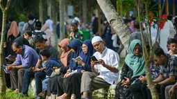 Orang-orang berdoa saat memperingati 18 tahun musibah gempa dan tsunami di kuburan massal Siron, Aceh, Senin (26/12/2022). Tsunami Aceh pada 2004 merenggut nyawa lebih dari 170.000 orang di Indonesia saja. (AFP/Chaideer Mahyuddin)