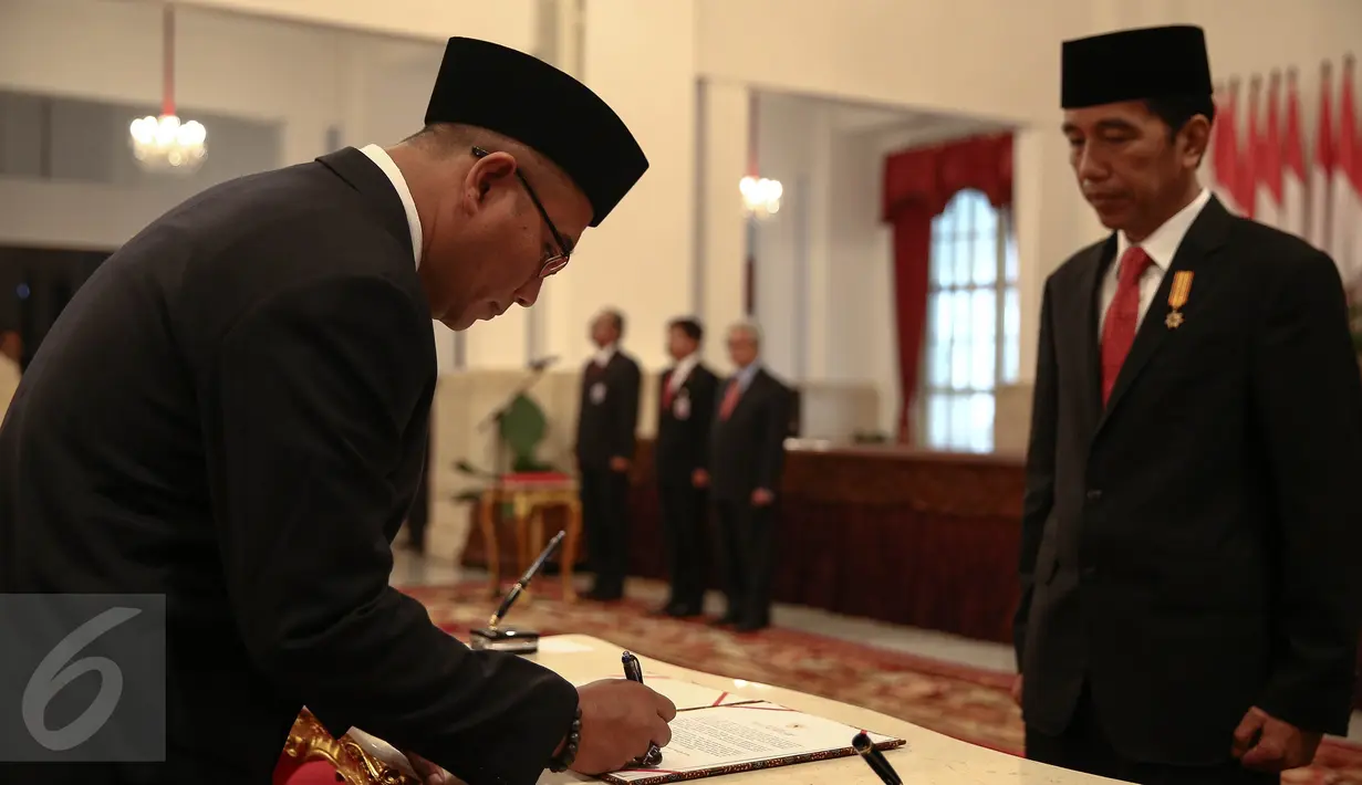 Hasyim Asy’ari disaksikan Presiden Jokowi menandatangi dokumen pelantikan sebagai anggota KPU di Istana Negara, Jakarta, Senin (29/8). Hasyim menjadi komisoner KPU meneruskan sisa periode Husni Kamil Manik hingga 2017.‎ (Liputan6.com/Faizal Fanani)
