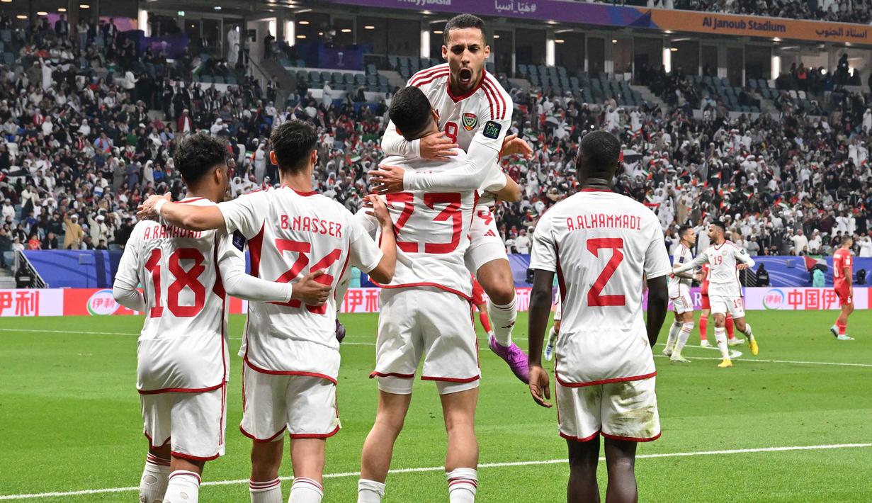 Penyerang Uni Emirat Arab (UEA) Sultan Adil (23) merayakan golnya dengan rekan setimnya saat pertandingan sepak bola Grup C Piala Asia Qatar 2023 melawan Palestina di Stadion Al-Janoub di Al-Wakrah, Doha pada 18 Januari 2024. (HECTOR RETAMAL/AFP)