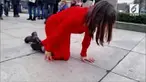 Tak seorang pun mengetahui maksud dari aksi perempuan 'berbaju merah' yang merangkak di sepanjang gedung parlemen Inggris ini.