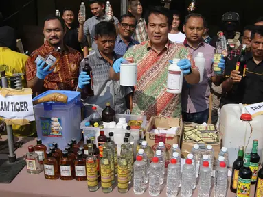 Kasatreskrim Polres Metro Jakarta Utara AKBP Febriansyah (tengah) menunjukkan barang bukti miras saat menggelar rilis hasil razia miras di Polres Metro Jakarta Utara, Jumat (6/4). (Liputan6.com/Arya Manggala)