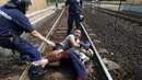 Polisi Hungaria saat akan menangkap keluarga migran yang ingin melarikan diri di stasiun kereta api di kota Bicske, Hongaria, 3 September 2015. (REUTERS/Laszlo Balogh)
