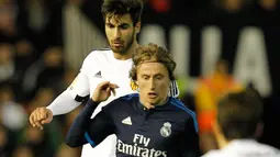 Gelandang Valencia, Andre Gomes (kiri) berusaha merebut bola yang dibawa gelandang Real Madrid, Luka Modric  pada lanjutan liga Spanyol di stadion Mestalla, (3/1/2015). Real Madrid bermain imbang dengan Valencia dengan skor 2-2. (AFP/JOSE JORDAN)