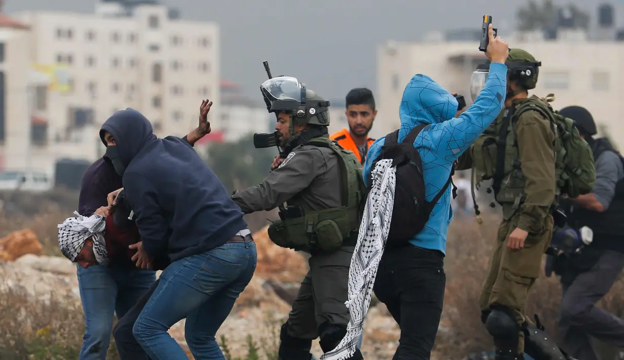 Polisi Israel menangkap seorang demonstran Palestina di kota Ramallah, Tepi Barat, (13/12). Sejumlah Polisi Israel menangkap warga Palestina dengan menyamar sebagai demonstran. (AP Photo / Nasser Shiyoukhi)