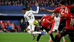 Bertanding di depan publik sendiri, Osasuna langsung menunjukkan keberanian tampil menekan pemuncak klasemen, Real Madrid. Tampak dalam foto, penyerang Real Madrid asal Prancis, Kylian Mbappe (kiri) saat berebut bola dengan gelandang Osasuna asal Spanyol, Lucas Torro Marset selama pertandingan pekan ke-25 La Liga 2025/2026 di Stadion El Sadar, Pamplona pada Sabtu 21 Februari 2026 waktu setempat atau Minggu (22/2/2026) dini hari WIB. (ANDER GILLENEA/AFP)