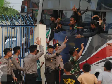 Suporter Persebaya 1927 atau Bonek berteriak dari dalam bus di Stadion Tugu, Jakarta, Rabu (3/8). Bonek menyerbu Jakarta sejak Selasa (2/8) untuk mendesak diagendakannya pengakuan klub Persebaya 1927 pada KLB PSSI. (Liputan6.com/Helmi Fithriansyah)