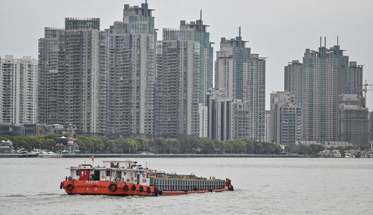 Kapal berlayar di sepanjang Sungai Huangpu di distrik Pudong yang dikunci sebagai tindakan pencegahan Covid-19, di Shanghai (28/3/2022). Jutaan orang di China pusat keuangan dikurung di rumah ketika bagian timur Shanghai dikunci untuk mengekang Covid terbesar di negara itu. (AFP/Hector Retamal)