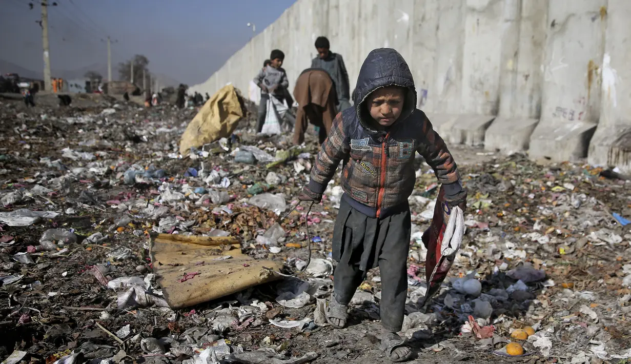 Seorang anak Afghanistan yang kehilangan tempat tinggalnya mencari barang-barang plastik dan lainnya yang dapat digunakan sebagai pengganti kayu bakar, di tempat pembuangan sampah di Kabul, Afghanistan (15/12/2019). (AP Photo/Altaf Qadri)