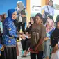 Plt Bupati Bone Bolango, Merlan Uloli saat menyerahkan bantuan PKH kepada penerima manfaat (Arfandi Ibrahim/Liputan6.com)