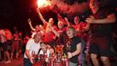 Suporter Liverpool merayakan gelar juara Premier League di depan Stadion Anfield, Kamis (25/6/2020). Titel juara Liga Inggris 2019-20 ini merupakan gelar pertama Liverpool setelah puasa selama 30 tahun. (AP/Jon Super)