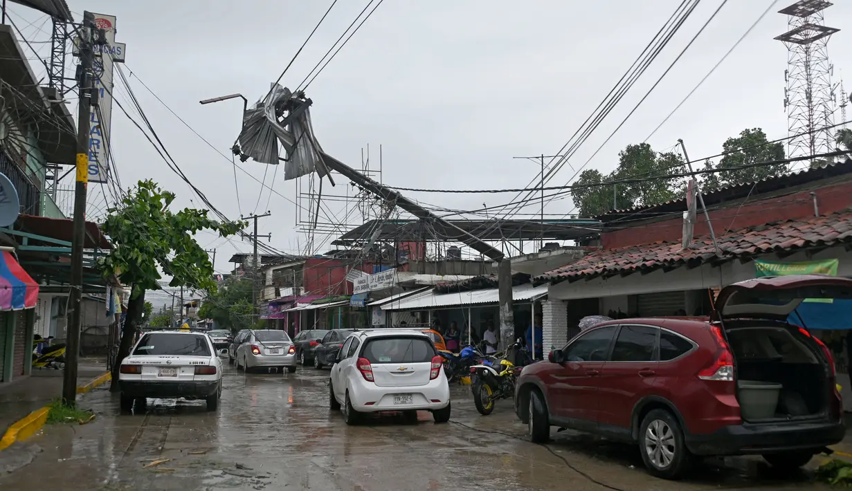 Badai tersebut menumbangkan pepohonan dan tiang listrik serta merusak atap bangunan. (Francisco Robles/AFP)