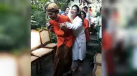 Presiden Jokowi berupaya menggendong putrinya, Kahiyang Ayu usai acara siraman.  (Liputan6.com/Pool/Mediacentresolo)