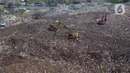 Alat berat eskavator  meratakan gunungan sampah di tempat Pembuangan Sampah Akhir (TPA) Burangkeng, Bekasi, Jawa Barat, Senin (6/5/2024). TPA Burangkeng rencananya akan memperluas lahan pembuangan sampah. (merdeka.com/Imam Buhori)