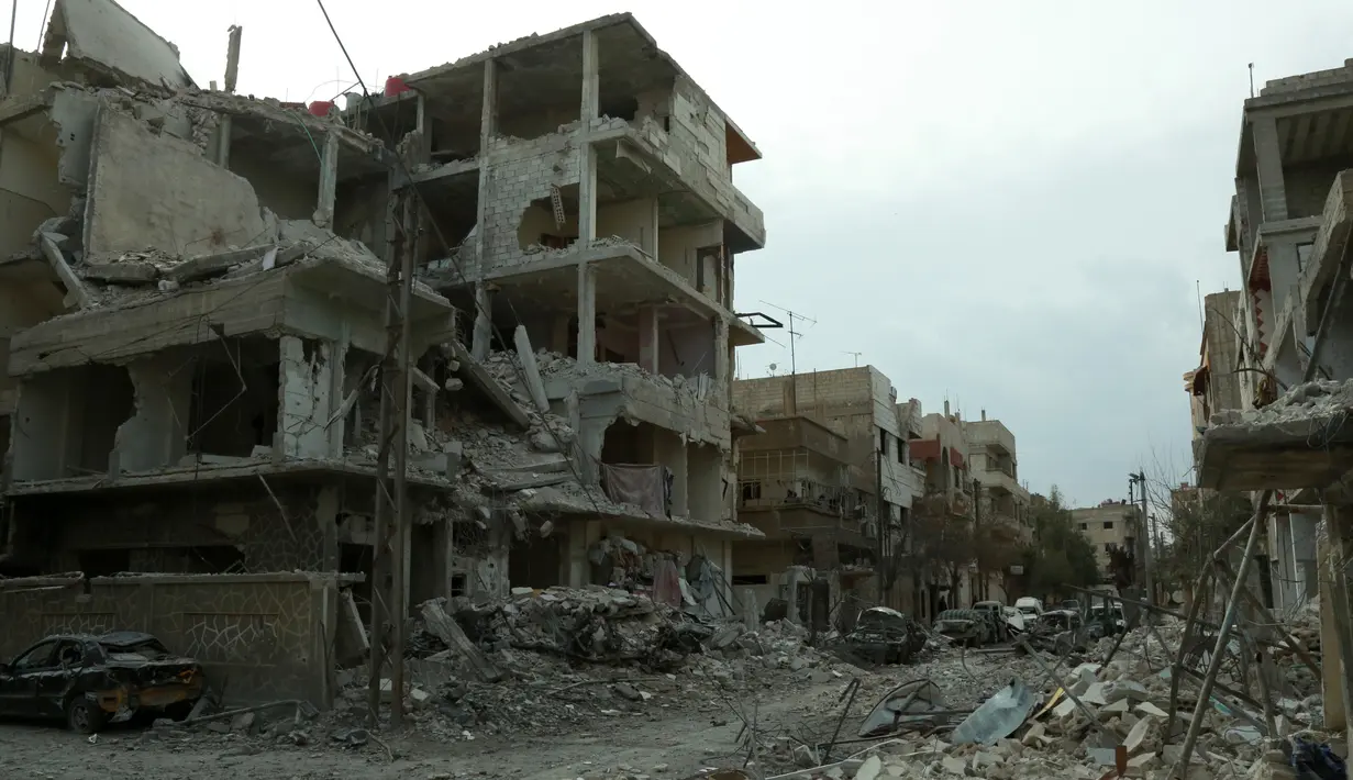 Kondisi Kota Douma di timur Ghouta yang bangunannya mengalami kerusakan, Minggu (25/2).  Rezim pemerintah Suriah masih terus menghujani kawasan Ghouta Timur sehingga jumlah korban tewas terus bertambah. (HAMZA AL-AJWEH/AFP)