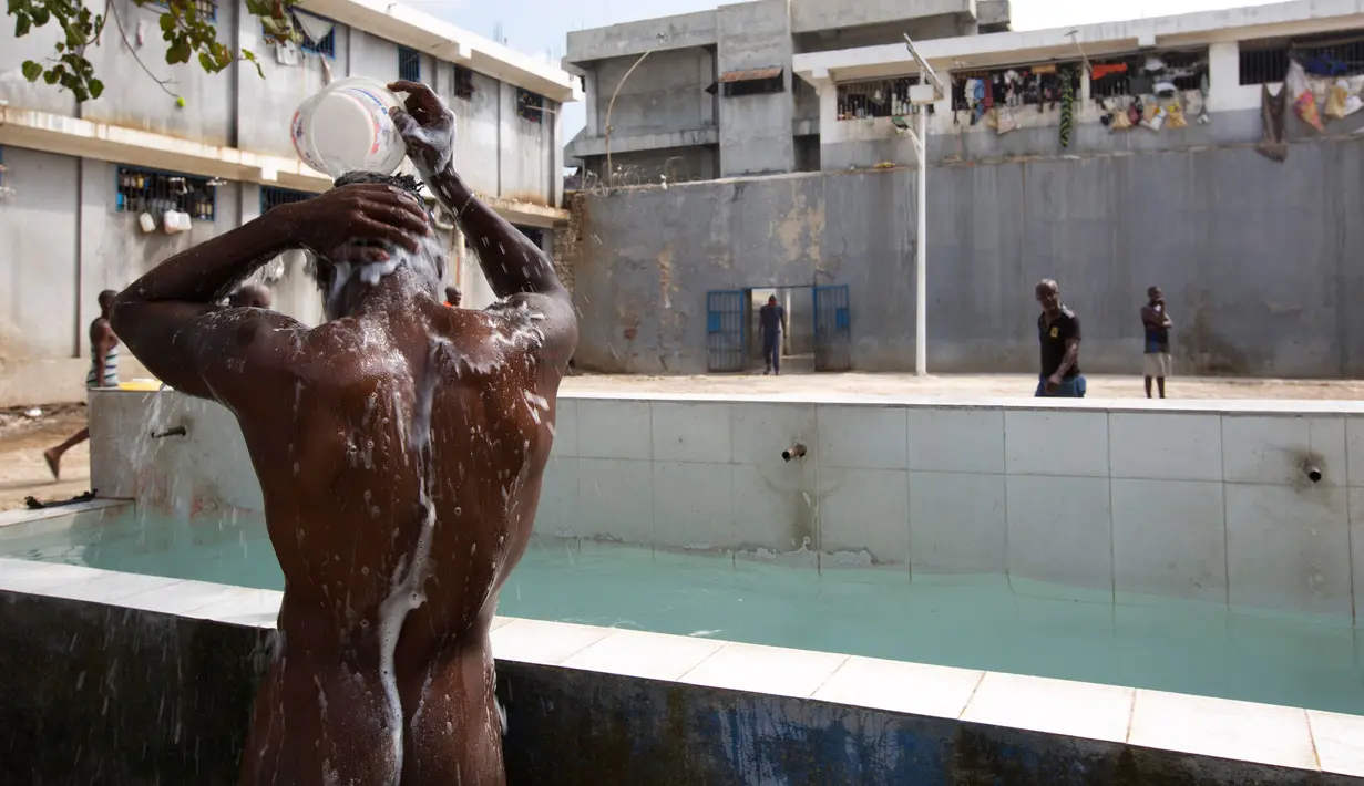 Seorang tahanan tengah mandi di tampat terbuka di dalam Lapas Nasional di pusat kota Port-au-Prince, Haiti, (13/2). Penuhnya Lapas ini membuat narapidana mengalami berbagai penyakit dan gizi buruk. (AP Photo/Dieu Nalio Chery)