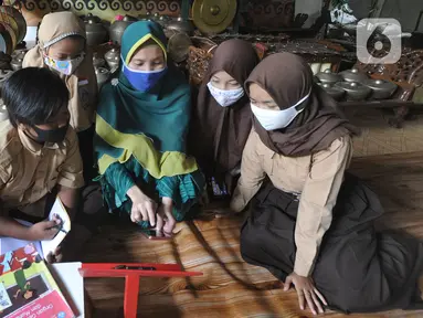 Siswa belajar secara daring menggunakan fasilitas wifi gratis di Perumahan Pondok Mulya I, Beji, Depok, Jawa Barat, Rabu (29/7/2020). Fasilitas tersebut disediakan oleh Sri Wiwoho untuk siswa sekitar perumahan. (merdeka.com/Arie Basuki)