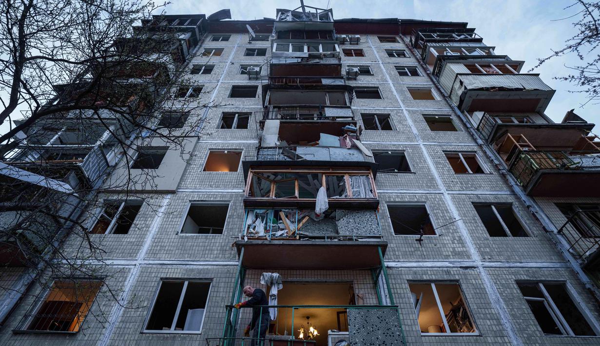 Sebagai informasi, invasi skala besar Rusia ke Ukraina secara resmi terjadi sejak 24 Februari 2022. Tampak dalam foto, seorang pria membersihkan puing-puing di dalam rumahnya yang rusak akibat serangan Rusia di lingkungan perumahan, Kyiv, Ukraina, pada Kamis 16 April 2026. (AP Photo/Evgeniy Maloletka)