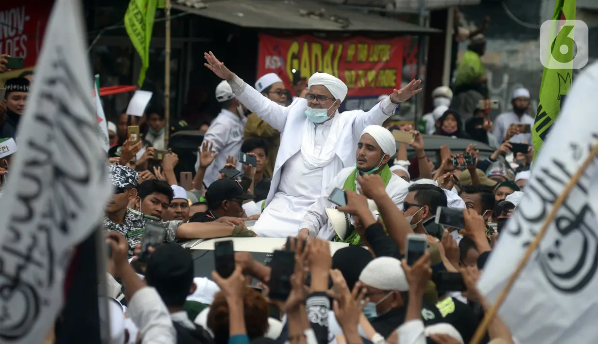 Rizieq Shihab menyapa massa pendukungnya saat tiba di kediamannya di Jalan Petamburan, Jakarta, Selasa (10/11/2020). Rizieq Shihab tiba di kediamannya usai pulang dari Arab Saudi. (merdeka.com/Imam Buhori)