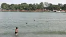 Anak-anak berenang di Danau Sunter, Jakarta, Selasa (23/7/2019). Minimnya fasilitas bermain yang layak dan murah membuat anak-anak nekat berenang di Danau Sunter. (merdeka.com/Iqbal Nugroho)