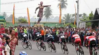 Para pebalap saat melewati Tugu Siti Manggopoh, Simpang Gudang, Kabupaten Agam di Etape 8 Tour de Singkarak 2015 Pasaman Barat-Lawang Park, Kabupaten Agam, Sabtu (10/10/2015). (Bola.com/Arief Bagus)