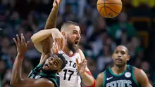 Forward Raptors, J Valanciunas (tengah) berebut bola dengan pemain Celtics  (AP Photo/Michael Dwyer)