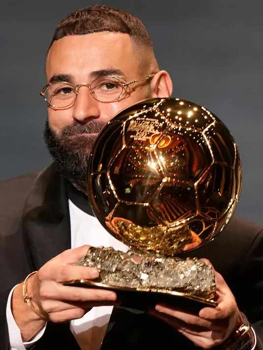 Pemain Real Madrid, Karim Benzema mengangkat trofi Ballon d'Or 2022 di Theater du Chatelet, Paris, Prancis, Senin (17/10/2022). Musim lalu, Benzema berhasil meraih empat trofi, Liga Spanyol, Liga Champions, dan Piala Super Spanyol bersama Real Madrid, serta UEFA Nations League bersama timnas Perancis. (AP Photo/Francois Mori)