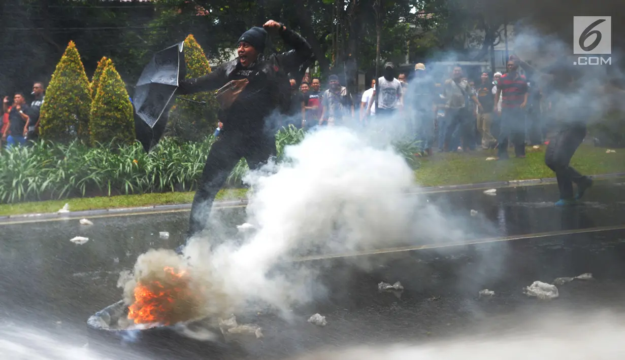 Massa membakar ban pada simulasi pengamanan Pemilu 2019 di depan Kantor KPU, Jakarta, Sabtu (16/3). Simulasi dalam rangka persiapan mengamankan Pilpres serta pemilihan legislatif pada 17 April mendatang. (merdeka.com/Imam Buhori)