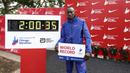 Pelari Kenya, Kelvin Kiptum berfoto bersama catatan waktunya di Chicago Marathon 2023 di Chicago, Illinois, Amerika Serikat, 8 Oktober 2023. Ia memecahkan rekor sebagai pelari marathon tercepat di dunia dengan mencatatkan waktu 2 jam 35 detik. (AFP/Kamil Krzaczynski)