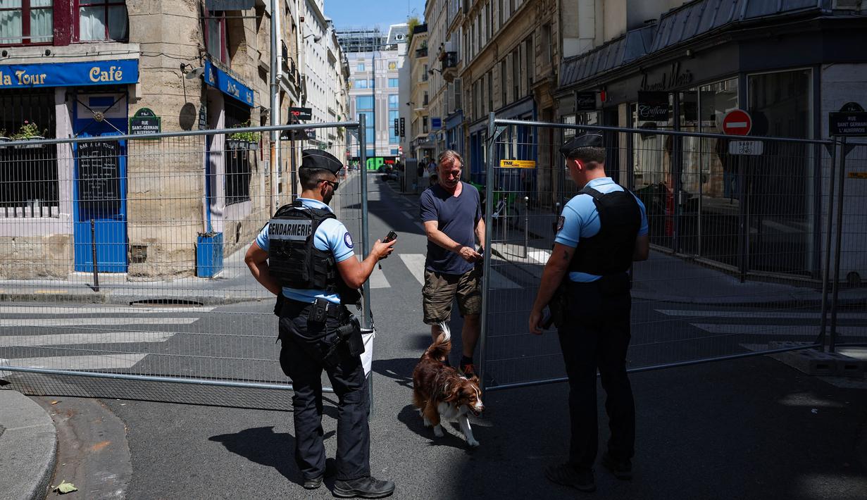 Polisi Prancis mengawasi seorang pejalan kaki di zona akses terbatas di Paris pada 19 Juli 2024. (EMMANUEL DUNAND/AFP)