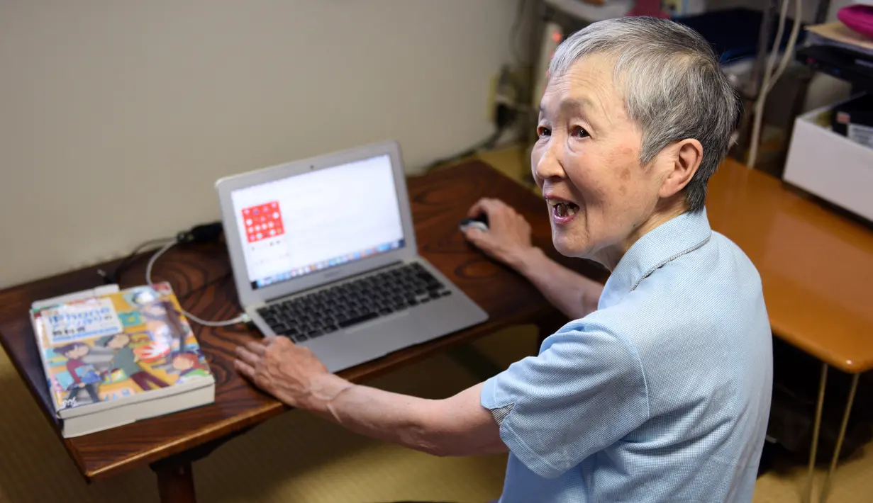 Masako Wakamiya (82) menggunakan laptop di rumahnya daerah Fujisawa, Prefektur Kanagawa, Jepang, 13 Juli 2017. Wakamiya kini menyandang predikat sebagai pengembang atau developer aplikasi berusia paling tua di raksasa gadget Apple. (Kazuhiro NOGI/AFP)
