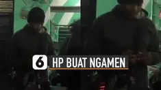 Ada-ada saja yang dilakukan oleh pria ini ketika mengamen karena menggunakan handphone saat memainkan alat musik.