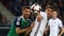Striker Jerman, Thomas Muller (kanan), dijaga ketat pemain Irlandia Utara, Gareth McAuley, pada laga Grup C Kualifikasi Piala Dunia 2018 zona Eropa, di HDI-Arena, Hanover, Rabu (12/10/2016) dini hari WIB. (Reuters/Kai Pfaffenbach)