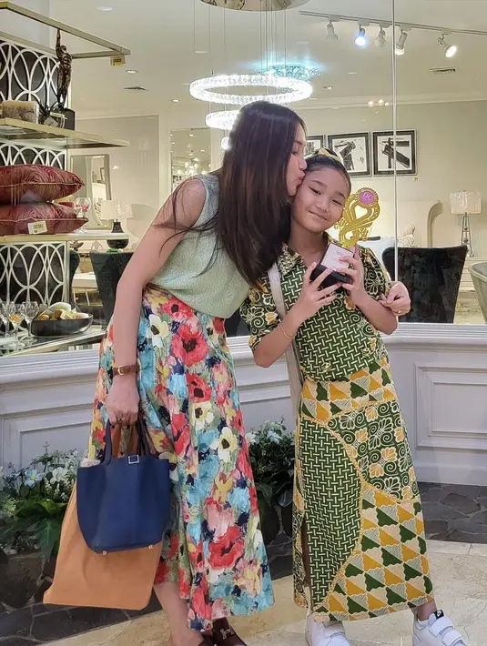 Potret Ayu Ting Ting mencium putrinya yang baru saja mengikuti mini konser piano. Momen tersebut juga dibagikan melalui vlognya, Qiss You TV. [Instagram/ayutingting92]